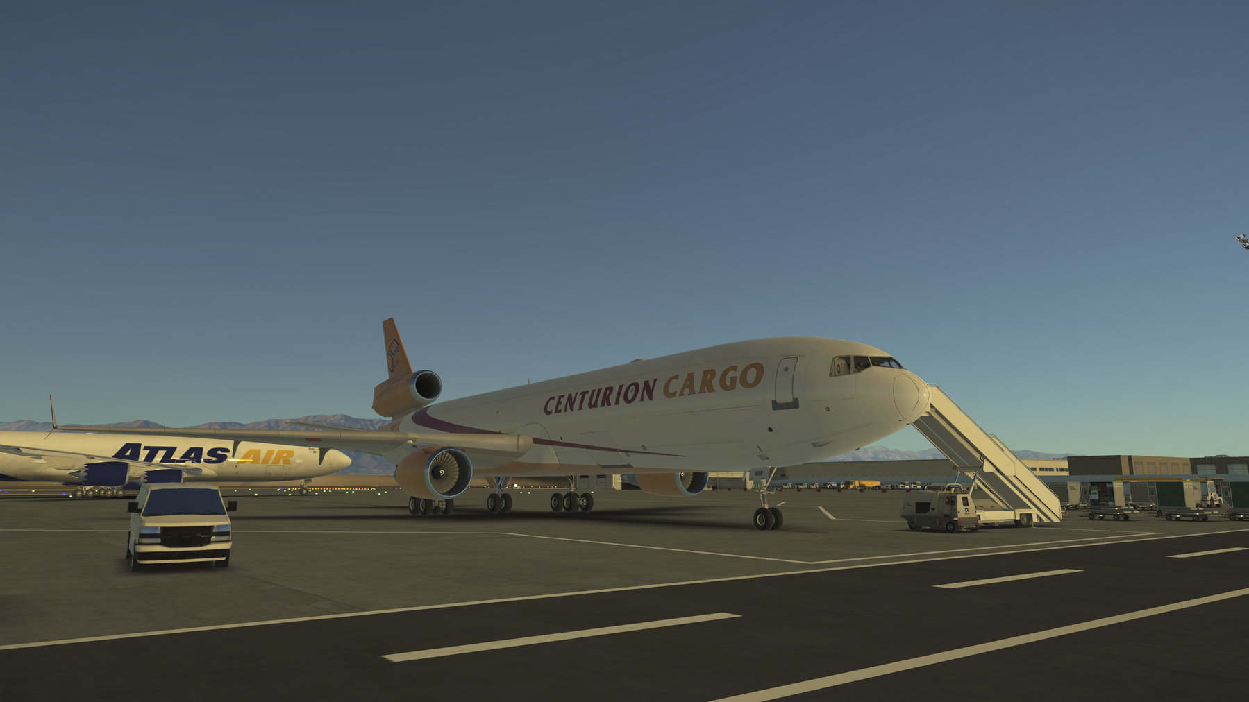 A Centurion Cargo MD-11F is parked on an airport tarmac with a mobile staircase connected and another Atlas Air plane visible in the background.